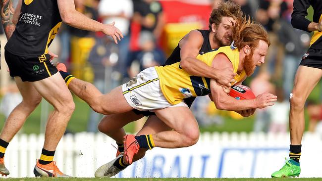 Woodville-West Torrens’ Angus Poole is tackled by Glenelg’s Matthew Snook. Picture: Tom Huntley