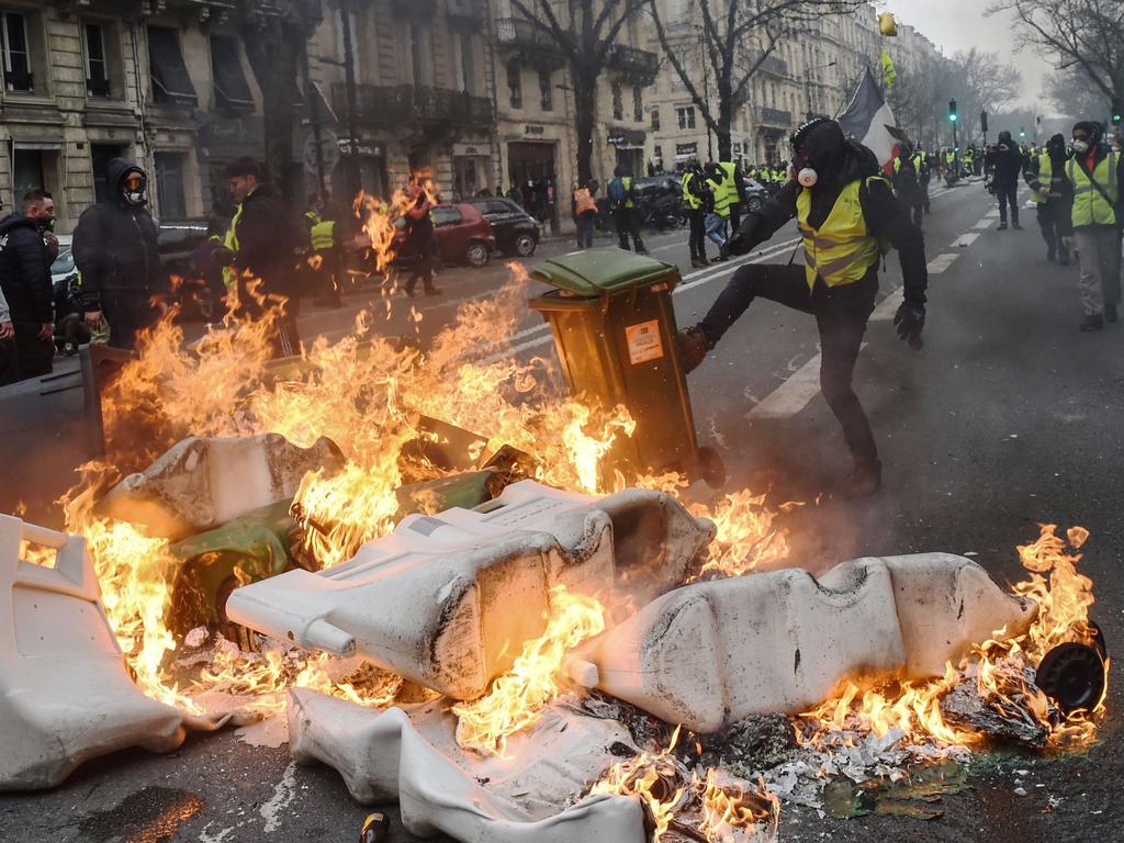 Anti-government demonstrators set fire to garbage bins in Bordeaux as the yellow vest movement morphs into a mass protest against Macron’s policies. Picture: AFP