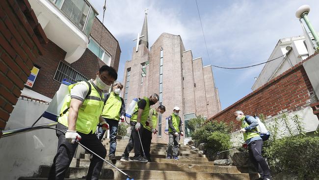 Quarantine officials disinfect as a precaution against the new coronavirus in Suwon, South Korea. Picture: AP