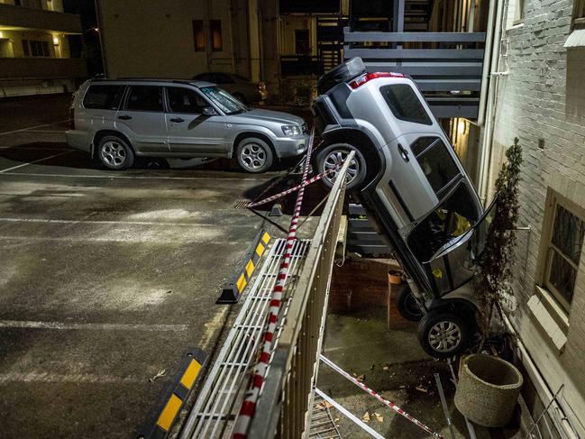 A car remain wedged between floors after crashing through the barrier of a first floor rooftop carpark at 33 Queens Rd, Melbourne. Picture: Jake Nowakowski