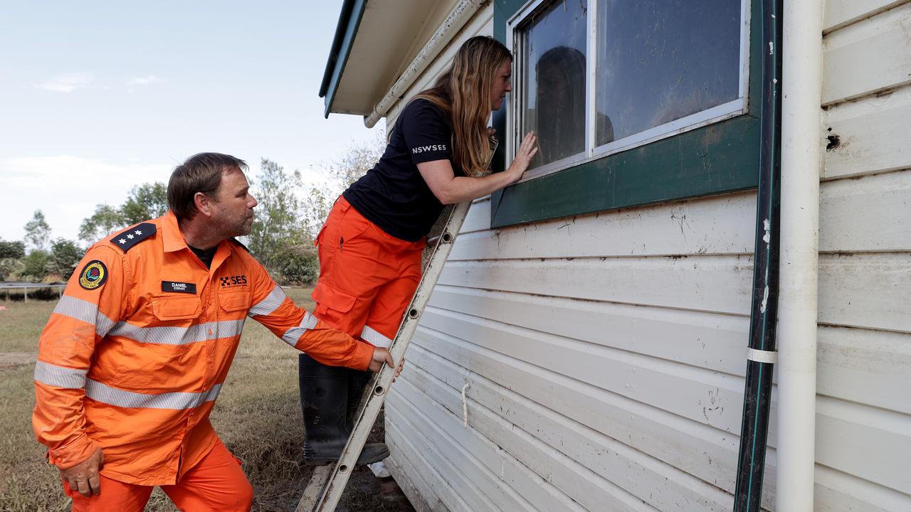 Nancy looks in through the window of her house to inspect the damage, which the couple haven’t had time to clean out yet. Picture: Toby Zerna