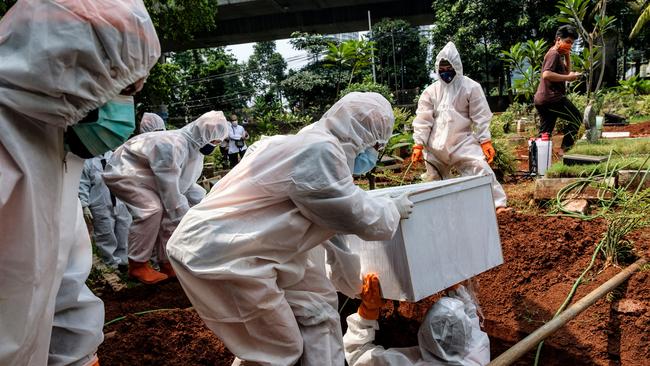 Government health workers bury a suspected victim of Covid-19, who died at home, in a neighborhood cemetery in Jakarta. Picture: Getty Images