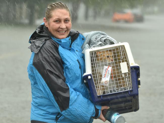 Sunday February 2. Heavy rain lashes Townsville causing flash flooding. Jo Martin carries her cat Kramer in Carmody Street, Rosslea. Picture: Evan Morgan