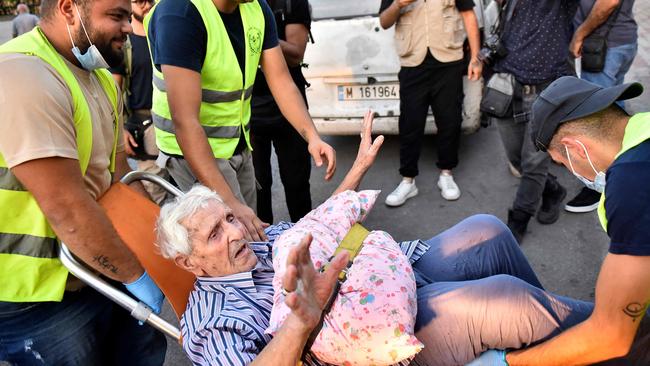 Volunteers carry an elderly man on a chair as people flee their villages in southern Lebanon. Picture: AFP.