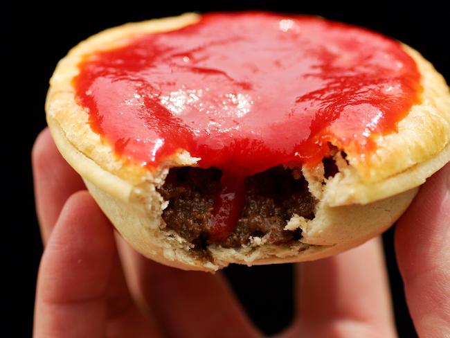 A Meat pie covered in sauce with a bite out of it