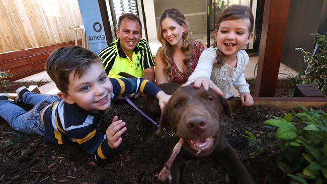 Steve and Sarah Kassiou with children Liam, 6, and Evelyn, 4 — and puppy Hazel — at the townhouse development they are building in Brisbane. Picture: Lyndon Mechielsen