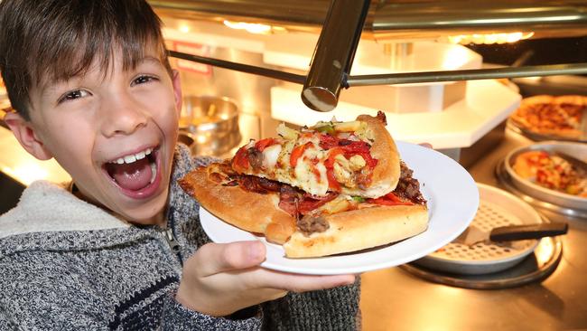 10-year-old Deshan Schokman enjoys his last slices of pizza. Pic Mike Batterham