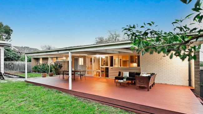 Buyers took shelter from the rain under the rear porch at the 51 Narbethong Drive auction.