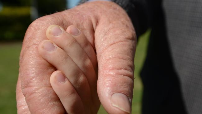 An old man's hand holding a child's hand. Photo Brenda Strong / The Observer.