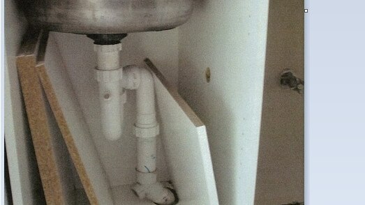 Under the sink at a Brisbane property where landlords had failed to complete the cupboard.