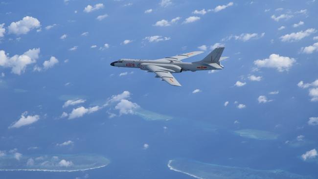 A Chinese H6K strategic bomber flies over disputed coral reefs in the South China Sea. Beijing is looking for similar island bases in the Indian and Pacific Oceans. Picture: Xinhua