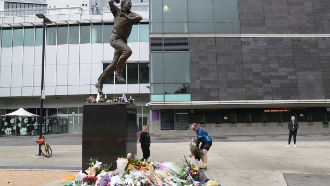 People lay flowers at the statue of Shane Warne at the Melbourne Cricket Ground after the cricket legend died at a Thai resort. Picture: NCA NewsWire