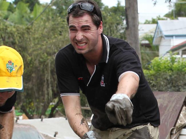 Flood cleanup in Brisbane's western suburbs. Strong Avenue, Graceville. The Coomera Magpies AFL club sent a busload of senior players and supporters to help out with the cleanup. back (L-R) Stephen Probst (yellow hat), Club President Garry Smith (no hat) and Ryan Balcombe (black hat).