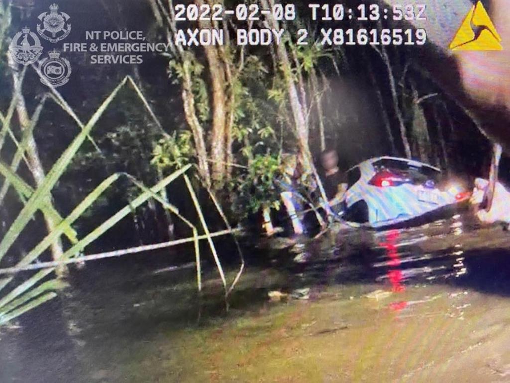 Emergency Services personnel rescue the driver of a car that was swept away in flood water after the driver attempted to cross a submerged rural road in the Virginia area. Picture: NT Police