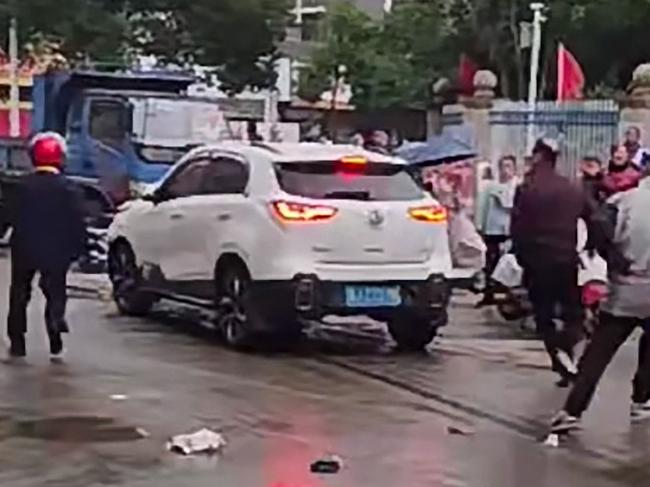 This frame grab taken from video footage circulating on Chinese social media on November 19, 2024 shows the scene where a car crashed outside the Yong'an primary school in Changde, central China's Hunan province, in which 