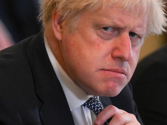 (FILES) In this file photo taken on May 24, 2022 Britain's then prime minister Boris Johnson adjusts his tie at the start of a cabinet meeting at 10 Downing Street in London. Johnson announced his resignation as an MP on June 9, 2023, accusing a parliamentary probe into the "Partygate" scandal of driving him out. Johnson, 58, said he was stepping down with immediate effect "triggering an immediate by-election" in his marginal seat, which heaps political pressure on his successor Rishi Sunak. (Photo by Daniel LEAL / POOL / AFP)