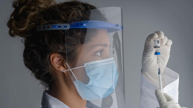 A Latin American frontline worker getting ready to apply a Covid-19 vaccine.