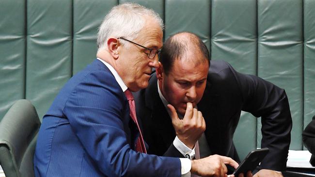 Australian Prime Minister Malcolm Turnbull confers with Minister for Energy Josh Frydenberg and gestures with a mobile phone during Question Time in the House of Representatives at Parliament House in Canberra, Monday, March 20, 2017. (AAP Image/Sam Mooy) NO ARCHIVING