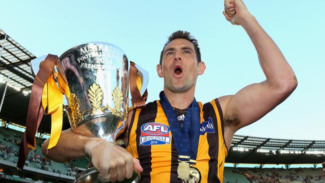 Luke Hodge with the premiership cup, premiership medal and Norm Smith Medal in 2014.