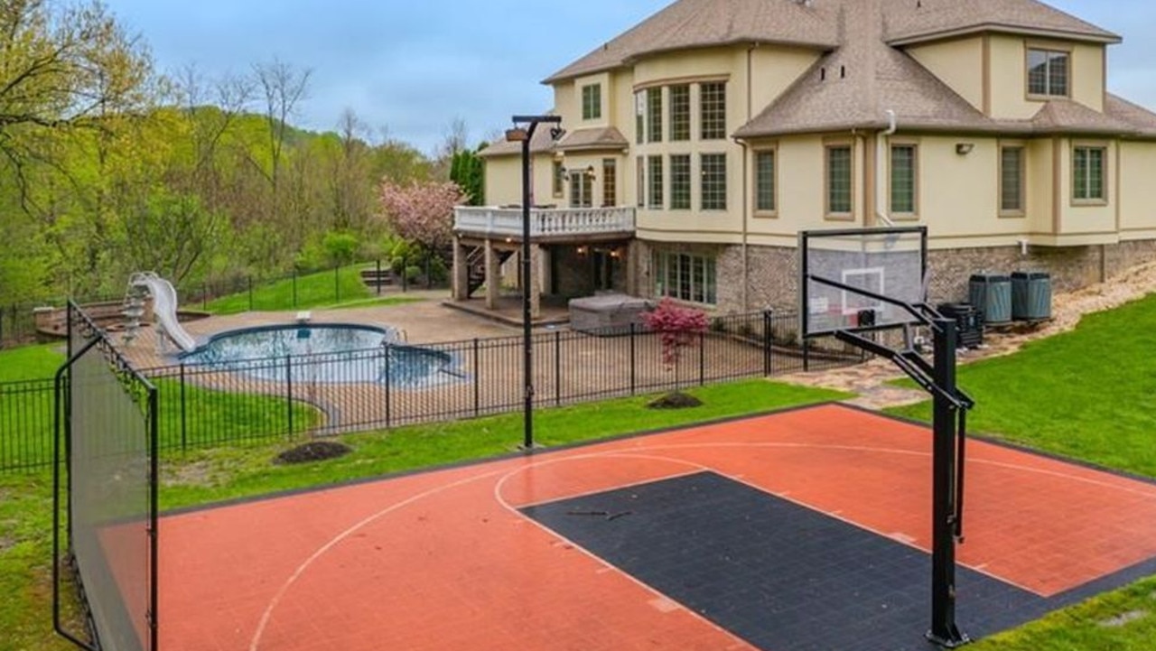 The gaudy McMansion has a backyard pool with a slide and a half-court basketball hoop.