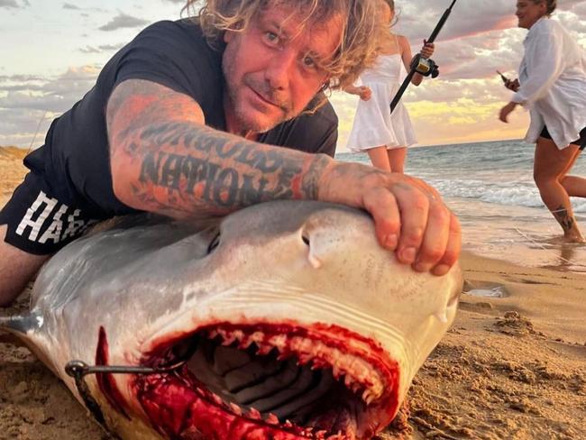 Mongols bikie Troy Mercanti captured with his prize possession after reeling it in off a WA beach. Picture: Facebook / Troy Mercanti