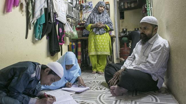 Mohammad Kheadir watches with his wife Sajeeda Begum, as his son Muqeeth, and his daughter Sana do homework at their home in Mumbai, India, February 9, 2016.