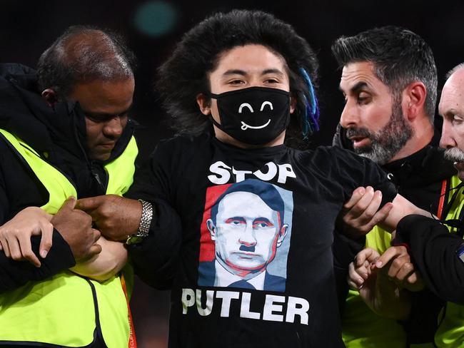 A pitch invader is carried away by security personnel. Picture: FRANCK FIFE / AFP.