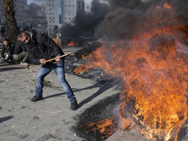 A Palestinian protester burns tires during clashes with Israeli troops following protests in the West Bank city of Ramallah. Picture: AP