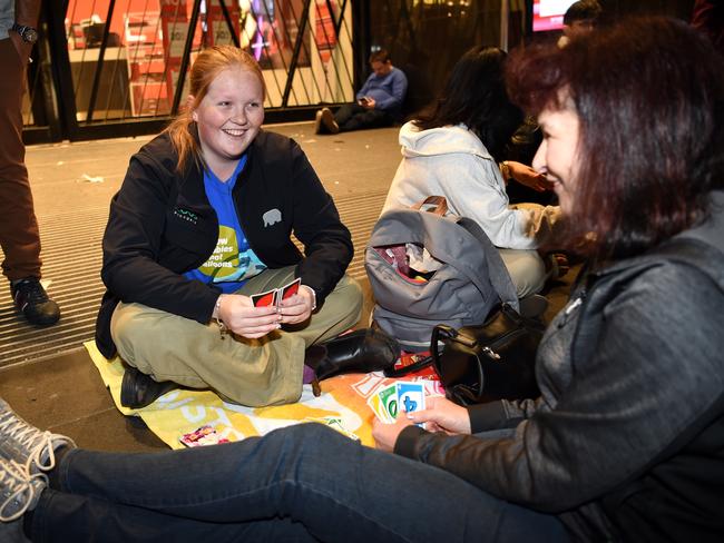 Shoppers played Uno at they waited in line outside Myer Picture: Nicole Garmston