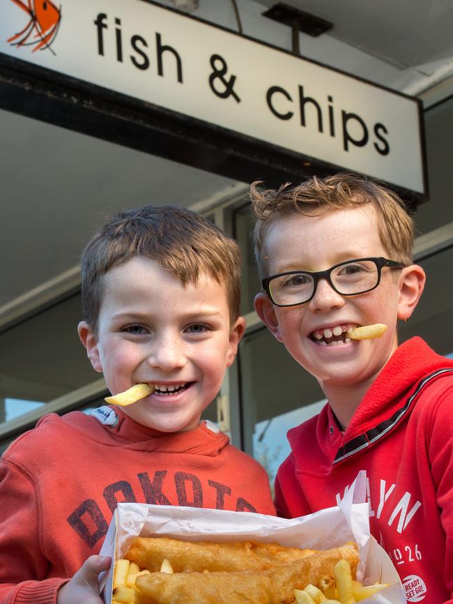 Ashley, 7, and Jack, 9, from Eltham tuck into some fish and chips. Picture: Jay Town.