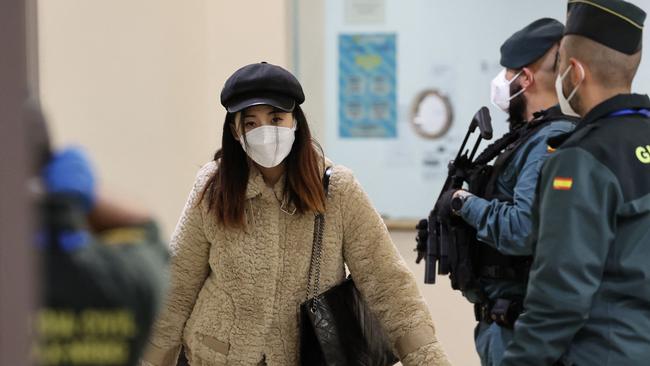 TOPSHOT - A passenger of a flight from Beijing leaves the terminal after landing at the Adolfo Suarez Madrid-Barajas airport in Barajas, on the outskirts of Madrid, on December 31, 2022. - The first flight from China after the reinstatement by Spain of health controls  on passengers from that country, in the midst of an explosion of covid cases, arrived in Madrid today evening. The passengers of the Air China CA 907 flight had to undergo temperature controls, present a negative covid test or prove that they were immunized with one of the vaccines approved in Spain upon arrival at Barajas, causing a scene not seen in months at the Madrid airport. (Photo by Pierre-Philippe Marcou / AFP)