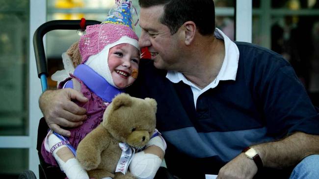 Sophie Delezio, with her father Ron, who was severely injured and burnt after car ploughed into Roundhouse Childcare Centre at Fairlight in December 2003, leaving Westmead Children's Hospital in Sydney to go home after six months there.