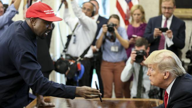 Rapper Kanye West shows a picture of a plane on a phone to US President Donald Trump during a meeting at the White House. Picture: Getty Images