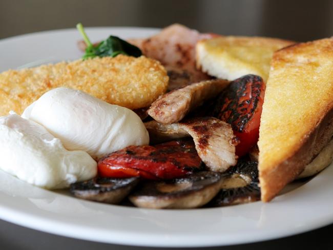 Poached eggs with bacon, sausages, mushrooms, mini potato cakes and toast served at Trovatino Cafe in Wareemba, Sydney.