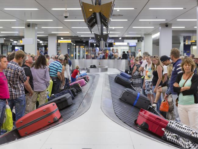 Travellers wait for their luggage at Schiphol Airport.