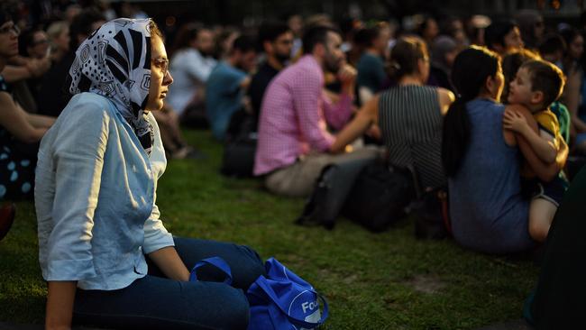 A woman watches on with thousands at a vigil for victims of the Christchurch massacre in front of Melbourne’s State Library. Picture: Jason Edwards