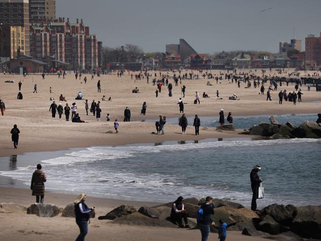 People keep their personal distance as they enjoy a spring afternoon at Brooklyn’s Coney Island yesterday. Picture: Getty Images