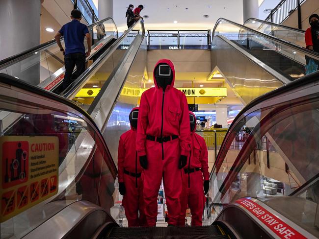 Cosplayers dressed in outfits from the Netflix series Squid Game ride an escalator at a shopping mall in Kuala Lumpur. Picture: AFP