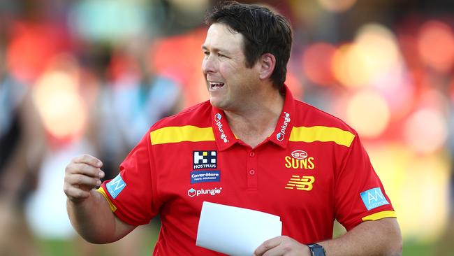 GOLD COAST, AUSTRALIA - JUNE 19: Suns coach Stuart Dew talks to players during the round 14 AFL match between the Gold Coast Suns and the Port Adelaide Power at Metricon Stadium on June 19, 2021 in Gold Coast, Australia. (Photo by Chris Hyde/Getty Images)