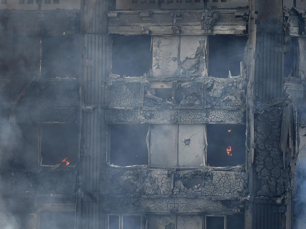 Fire still burns and smoke rises from the thoroughly burnt upper storeys of the Grenfell Tower. Picture: Leon Neal/Getty Images