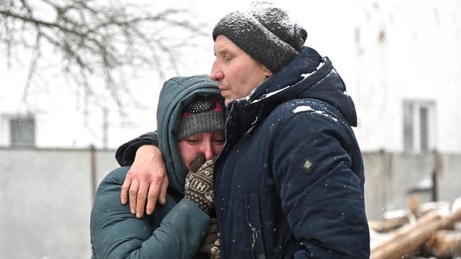 TOPSHOT - Local residents react next to the site hit after Russian strikes in Zmiiv, Kharkiv region, on January 8, 2024, amid the Russian invasion of Ukraine. At least three people have been killed and dozens injured in a fresh wave of Russian strikes across Ukraine, regional officials said on January 8, 2024. In the eastern region of Kharkiv, an elderly woman who was pulled from the rubble of her house in the city of Zmiiv died, regional governor Oleg Synegubov said. (Photo by SERGEY BOBOK / AFP)