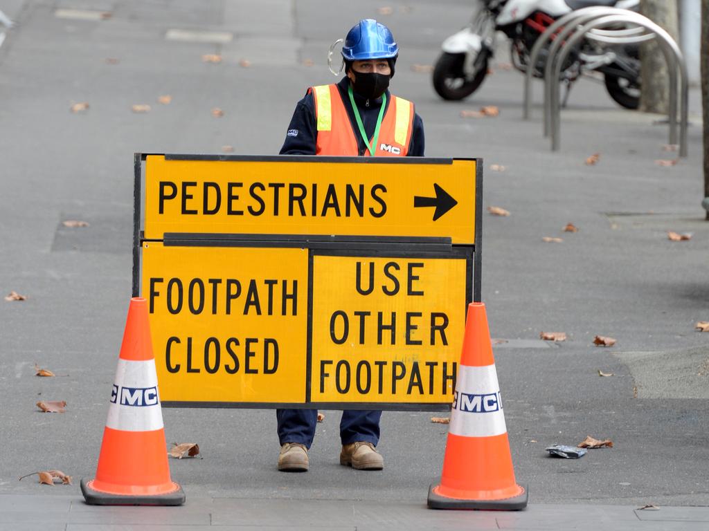 Workers move the few pedestrians away from Melbourne’s city centre during the morning peak. Picture: NCA NewsWire / Andrew Henshaw