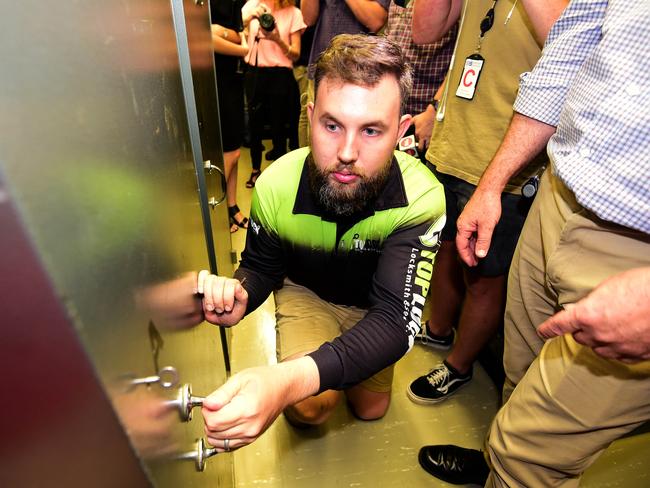 Top Lock NT locksmith Ed Brooke works on the vault door as NT Heritage branch officials and members of the media look on. Picture: Justin Kennedy