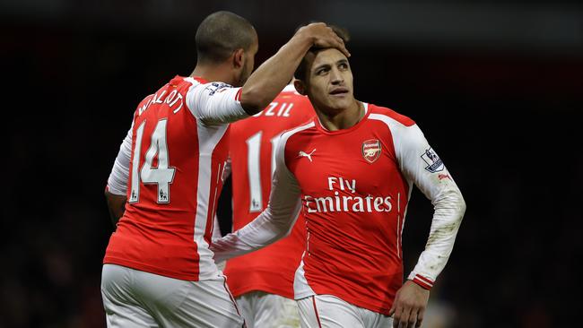 Arsenal's Theo Walcott, left, celebrates scoring his side's second goal with Alexis Sanchez during the English Premier League soccer match between Arsenal and Leicester City at the Emirates Stadium in London, Tuesday, Feb. 10, 2015. (AP Photo/Matt Dunham)