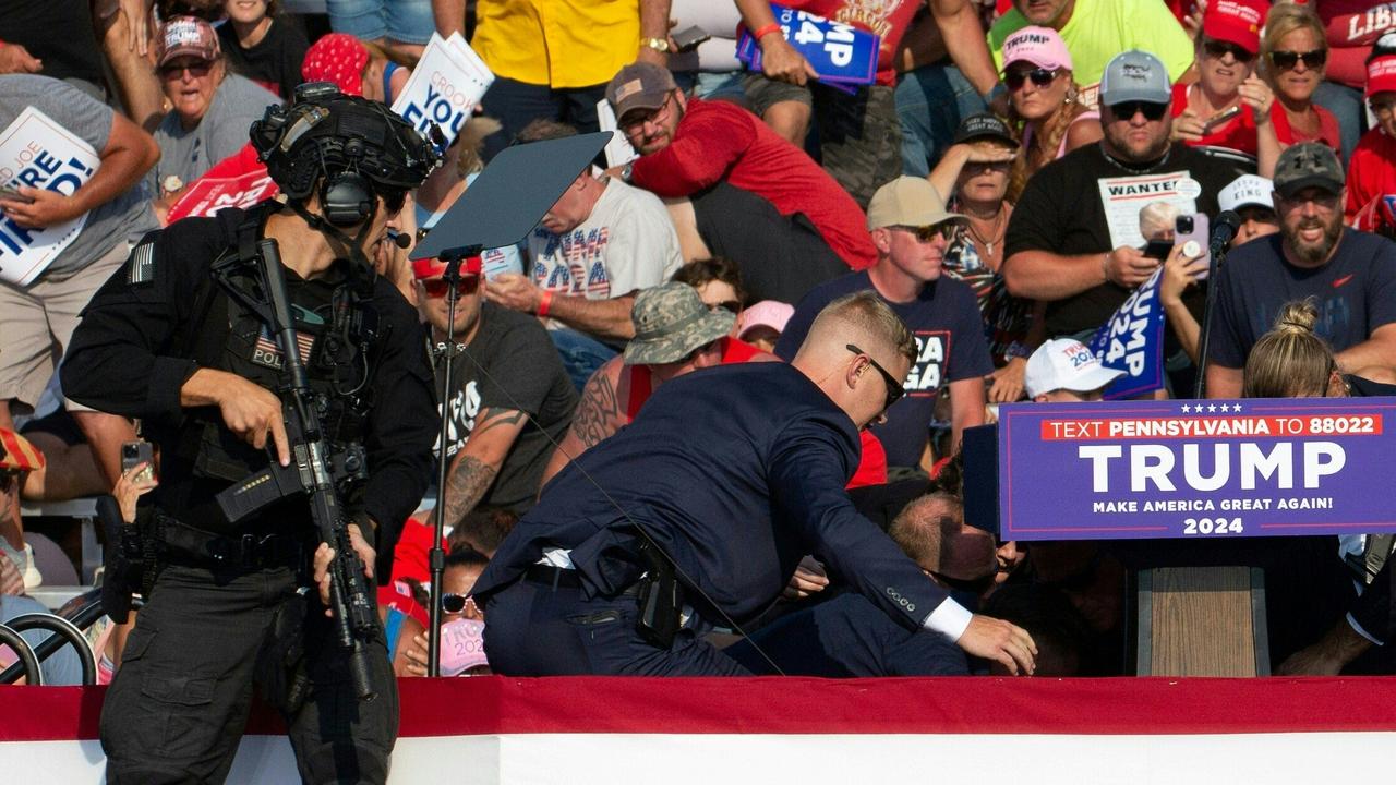 Seconds after he was shot, Republican candidate Donald Trump is surrounded by secret service agents on the floor. Picture: Rebecca Droke