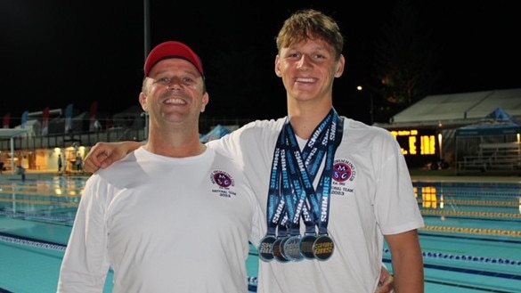 (L-R) Coach Justin Rothwell with Josh Kerr and his collection of six medals from the Australian Championships. Picture: Manly Swimming Club