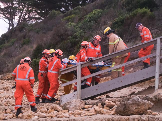 Emergency crews work to free and transport a woman who become stuck in rocks at Torquay between Cosy Corner and Fishermans Beach. Pictures: Shaun Viljoen