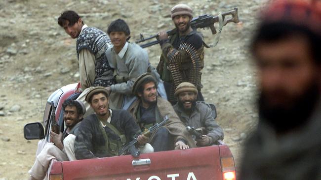 Afghan fighters smile from the back of a Toyotanear Tora Bora, Afghanistan, in 2001.