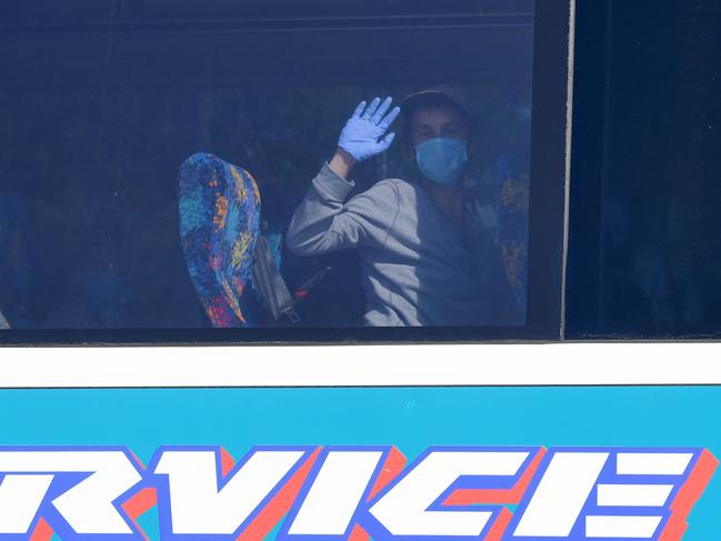 Crew from the disease-stricken Ruby Princess wave as they leave the ship from Port Kembla by coach to hotels in Sydney before flying home.