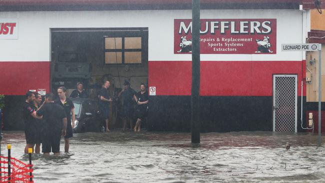 Major flooding in Currumbin Creek rd at Currumbin. Workers watch the crisis unfold in front of them. Picture Glenn Hampson